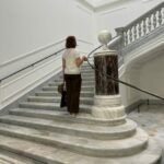 Une visiteuse dans l’escalier en marbre du Palazzo Marignoli à Rome