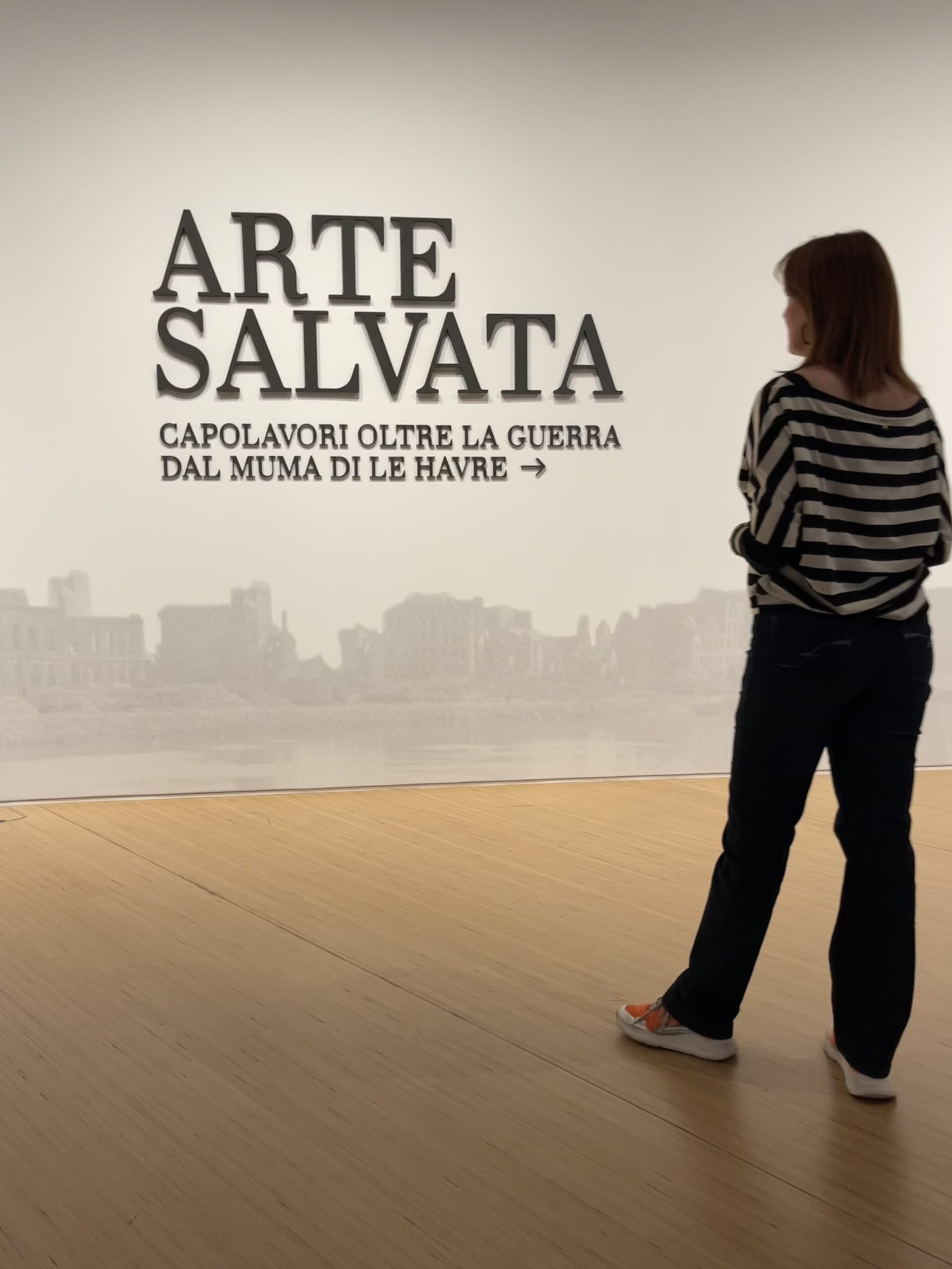 Sabrina Egidi beside the Arte salvata exhibition title at M9 Museum in Mestre