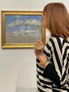 Sabrina Egidi osserva Studio di nuvole su cielo blu di Eugène Boudin, in cornice dorata